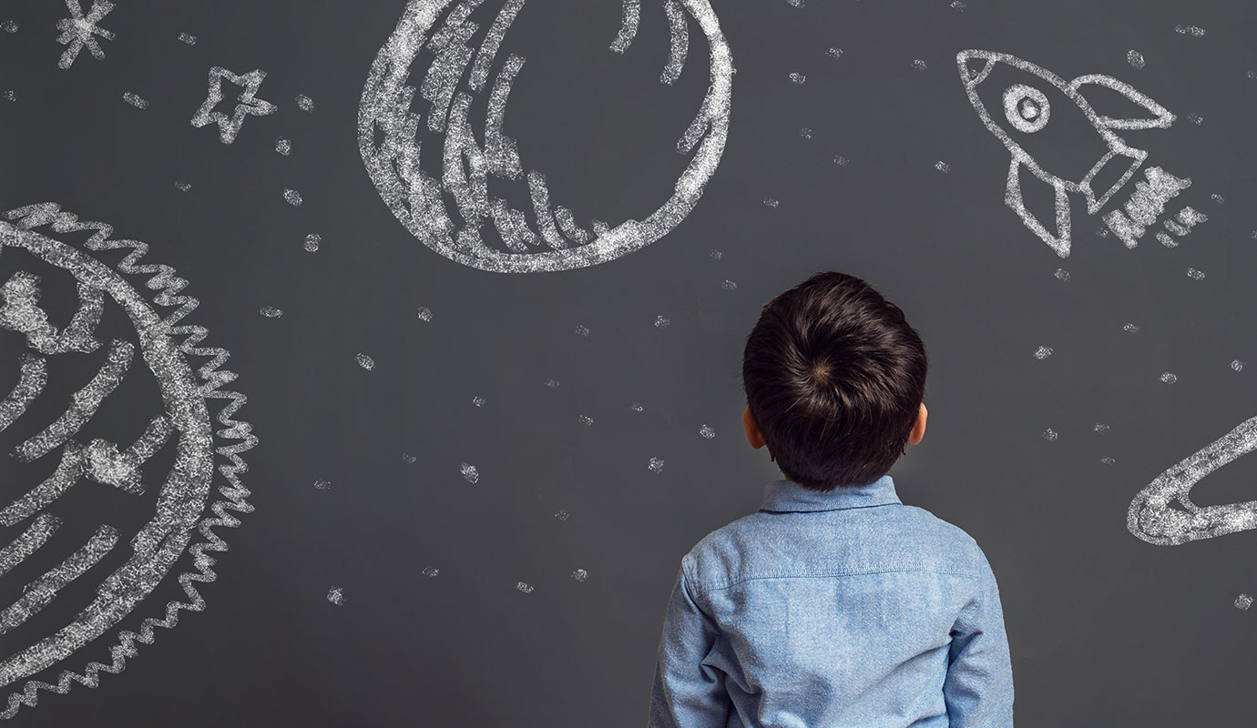 Young child looking at chalkboard 