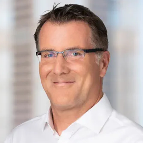 A man in glasses smiling for the camera 